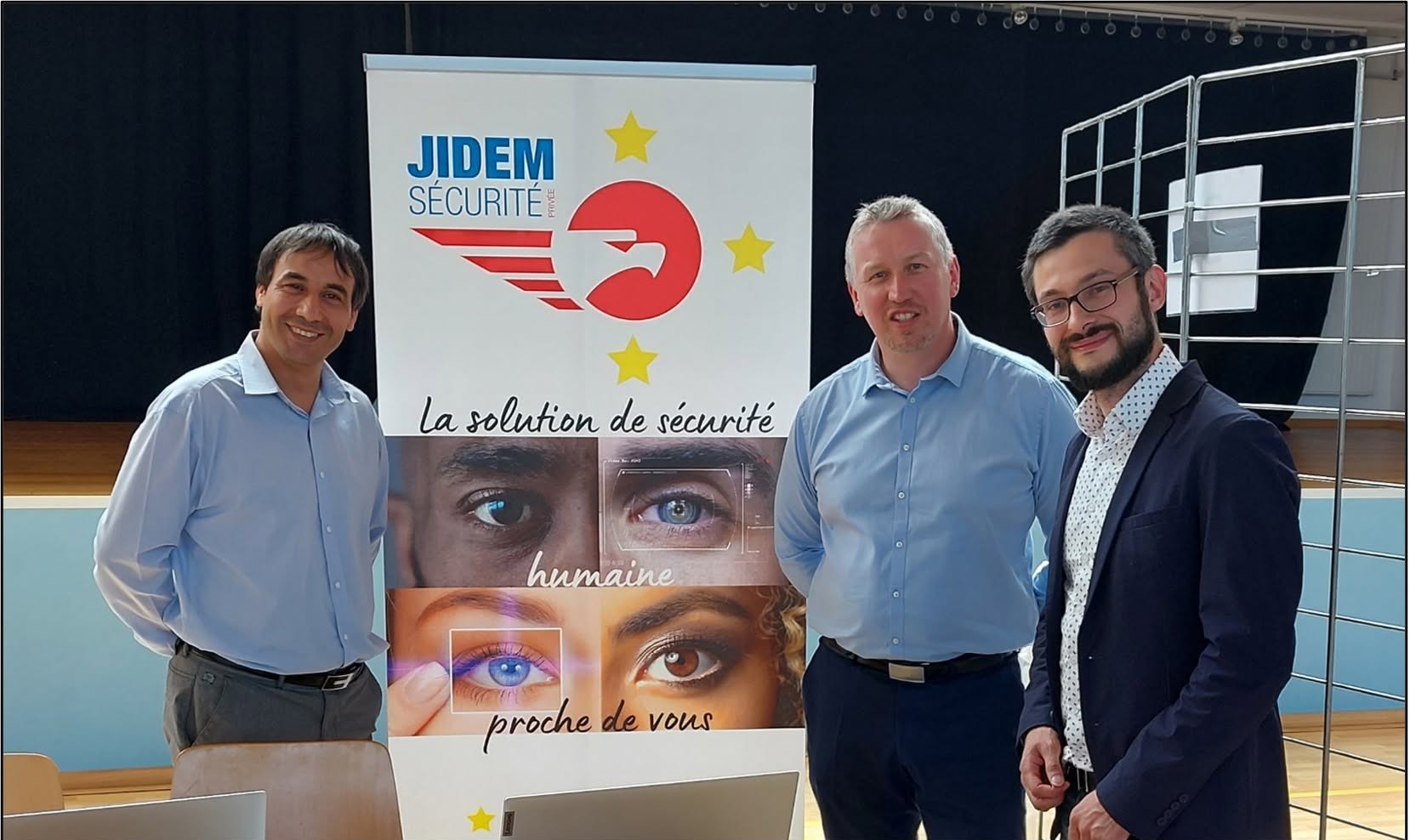 Équipe JIDEM Sécurité Privée devant le kakémono « La solution de sécurité humaine proche de vous »